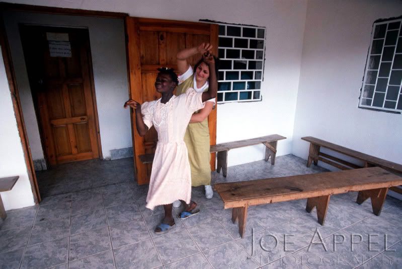 Jami Craig and a girl named Fenette celebrate the end of a long day with a dance in the waiting room of the clinic in La Croix, Haiti.